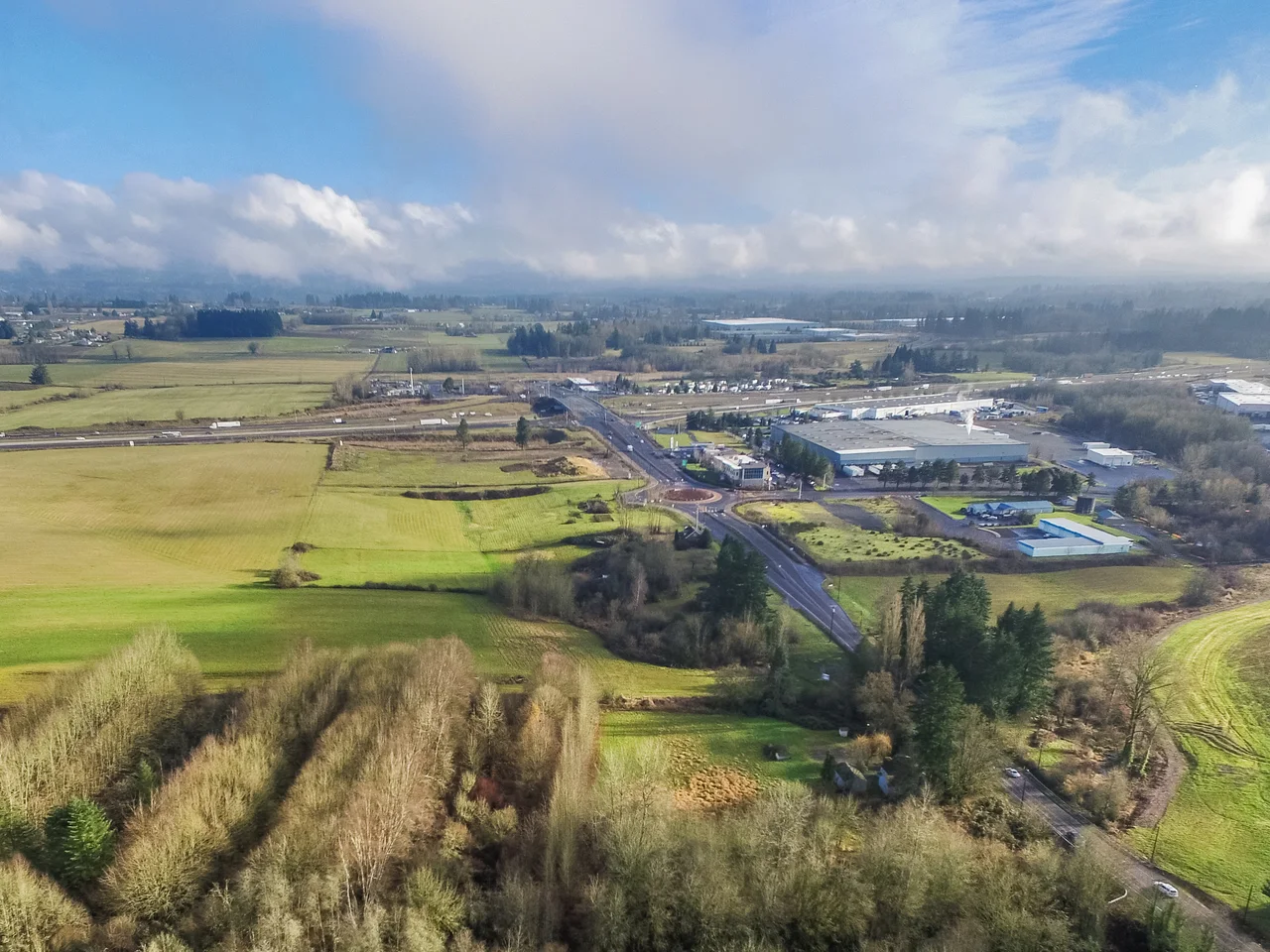 Aerial view across rural land, roads, and the surrounding community