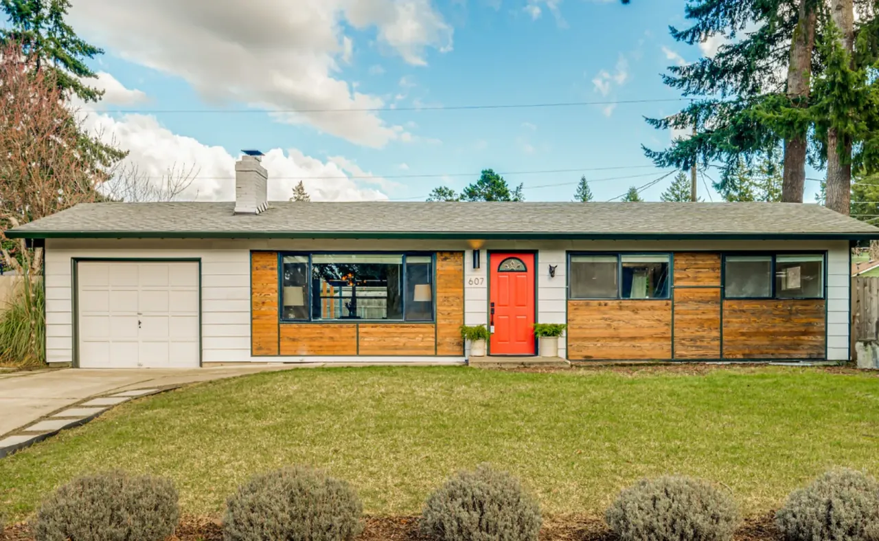 A carefully photographed single-story home with a distinctive red front door