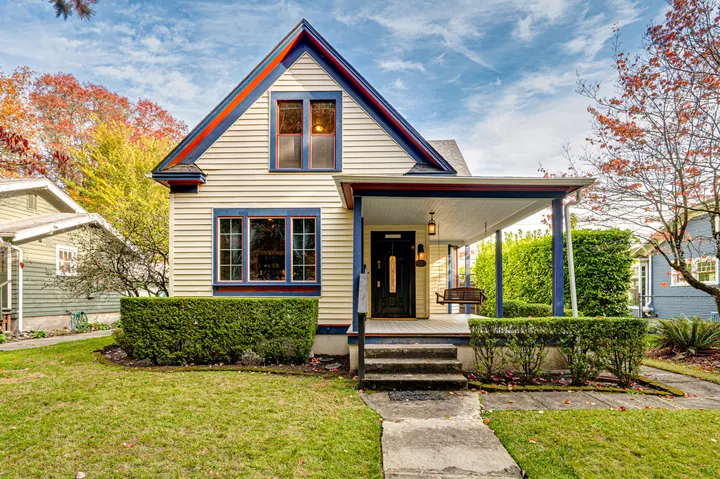 Small home framed by trees and a front garden