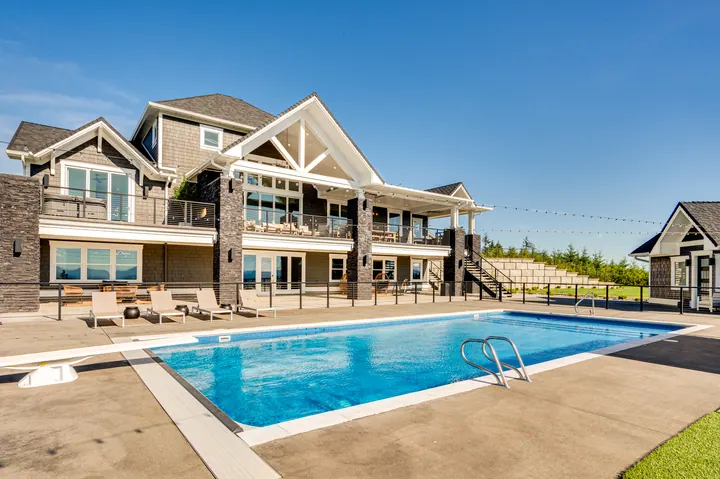 Pool and outdoor living area beside a large home