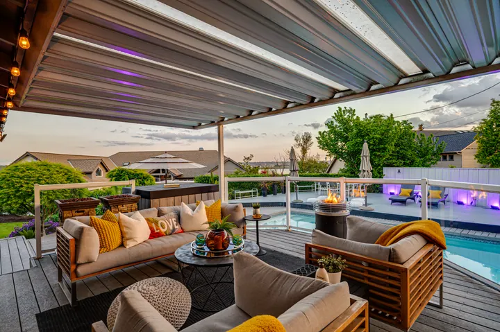 Covered outdoor seating beside an illuminated pool
